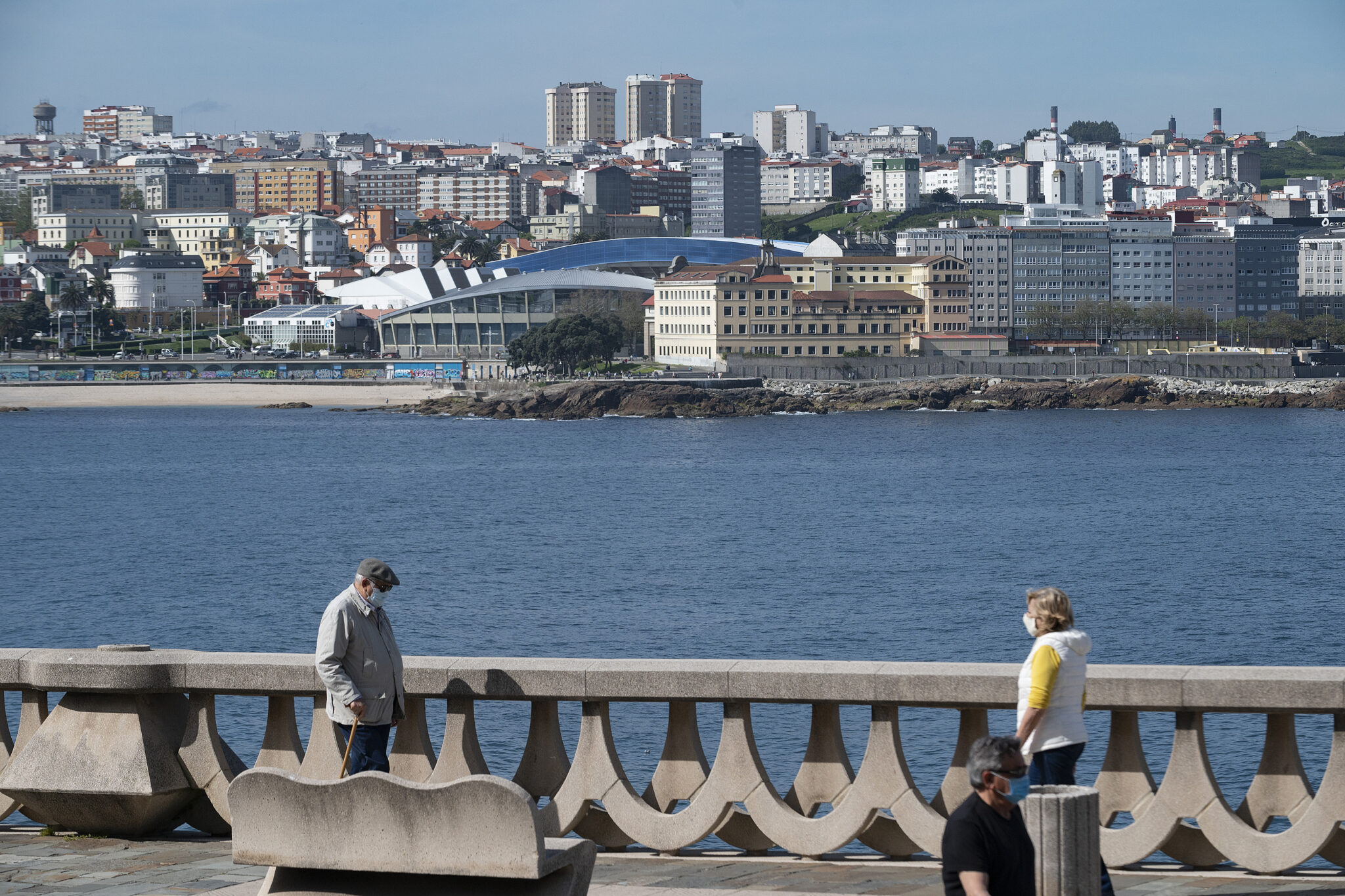 Arquivo - Dúas persoas pasean polo paseo marítimo da Coruña (Galicia), co estadio de Riazor de fondo. M. Dylan - Europa Press - Arquivo