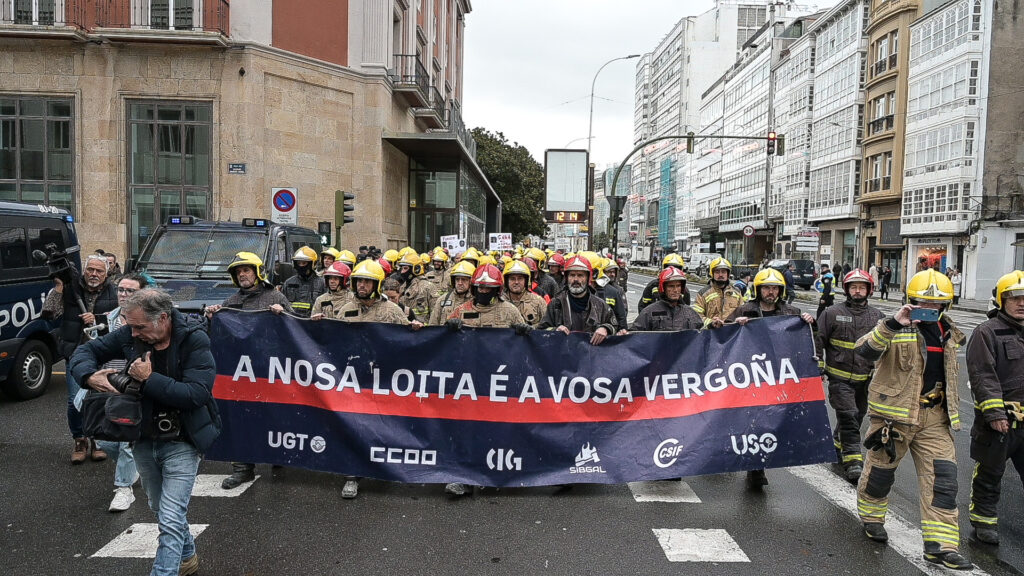 Bombeiros dos parques comarcais suxeitan unha pancarta durante unha concentración fronte á Deputación da Coruña. M. Dylan - Europa Press
