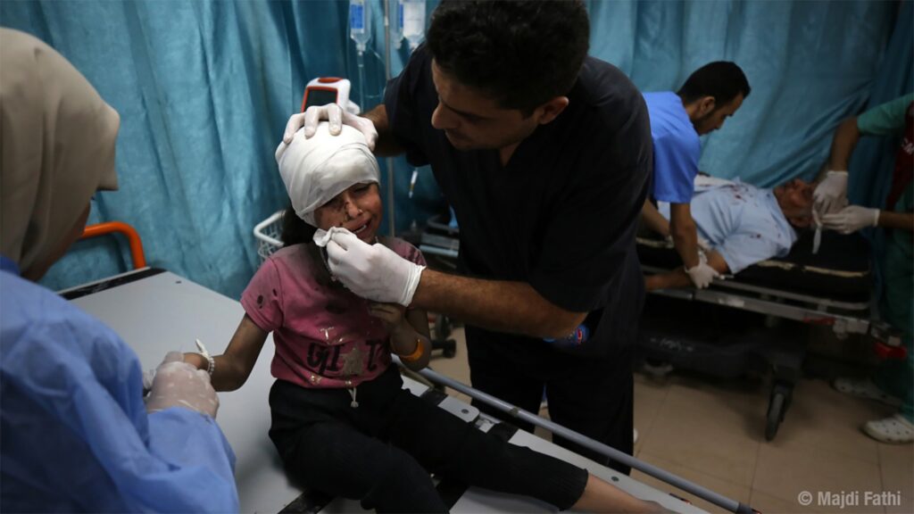 Médico atendendo neno ferido en Gaza. Foto de Majdi Fathi